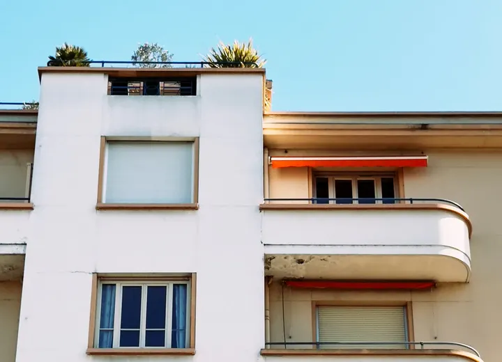Immeuble résidentiel moderne avec balcons et stores rouges en France
