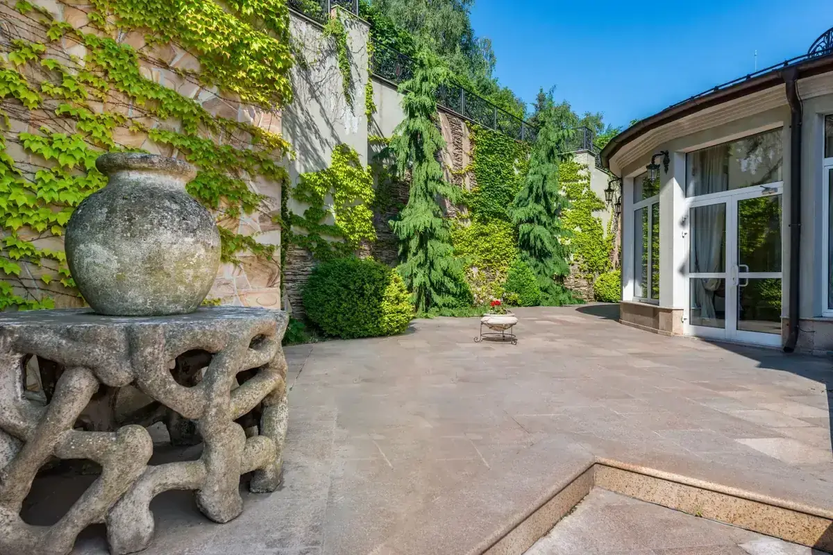 Terrasse aménagée avec mobilier et végétation près d’une maison
