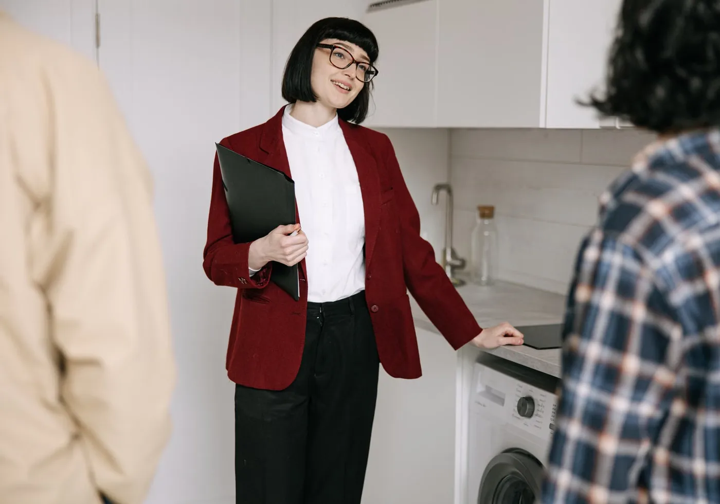 Agent immobilier faisant visiter une cuisine moderne à deux personnes